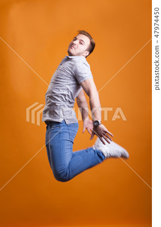 Young man jumping in the air from happiness Young man jumping in the air from happiness 47974450