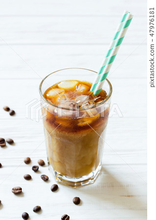 Coffee with ice, milk and striped straws in glass Coffee with ice, milk and striped straws in glass 47976181