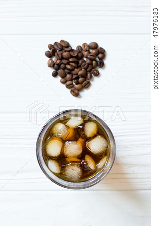 Coffee with ice and heart coffee beans. Top view Coffee with ice and heart coffee beans. Top view 47976183