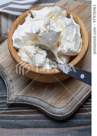 Traditional Mascarpone cheese in wooden bowl on table 47976461