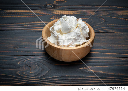 Traditional Mascarpone cheese in wooden bowl on table Traditional Mascarpone cheese in wooden bowl on table 47976534