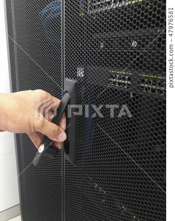 Man open the door of computer server rack 47976581
