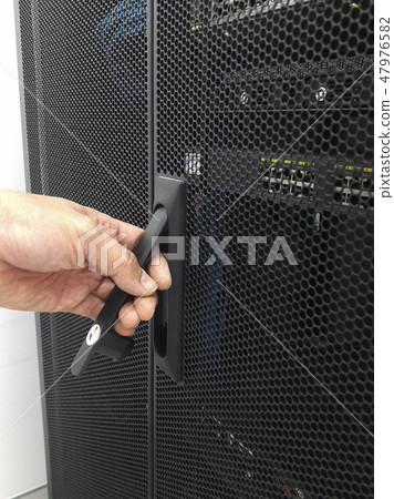 Man open the door of computer server rack Man open the door of computer server rack 47976582