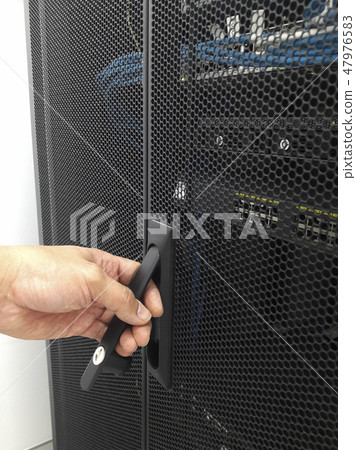Man open the door of computer server rack 47976583