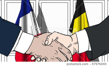 Businessmen or politicians shake hands against flags of France and Belgium. Official meeting or 47976840