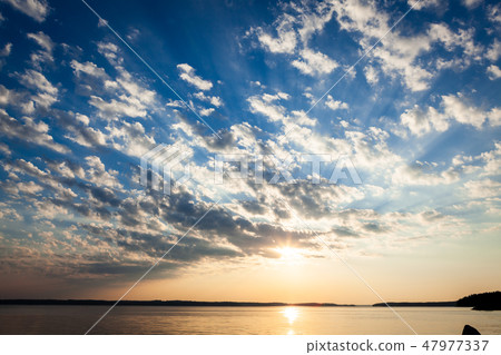Clouds and sunrays at sunrise 47977337