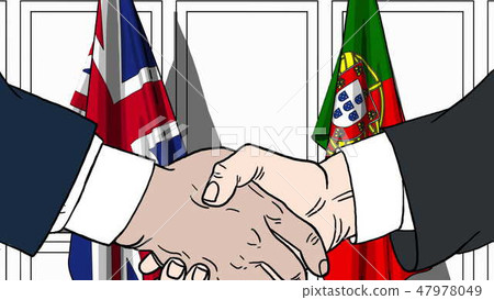 Businessmen or politicians shake hands against flags of Britain and Portugal. Official meeting or 47978049