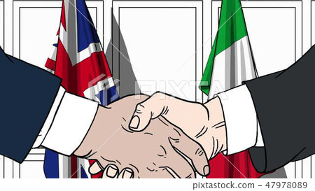 Businessmen or politicians shaking hands against flags of Great Britain and Italy. Meeting or 47978089