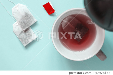 Ceramic cup with red fruit tea and paper tea bags 47978152
