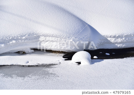 In the winter Hokkaido Yakumo Town Yaguma Toge Pass Under the rocks of the river bed of the Makubabe River a heavy snow was piled up and taken a scenery of Mokomoko 47979165