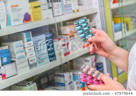 Pharmacist holding medicine capsule pack  47979644