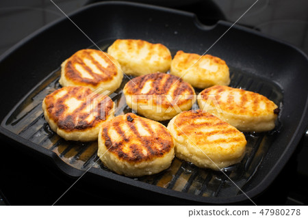 Traditional Russian sweet syrniki cottage cheese pancakes fried in the frying pan Traditional Russian sweet syrniki cottage cheese pancakes fried in the frying pan 47980278