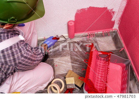 House painter at work painting the wall 47981703