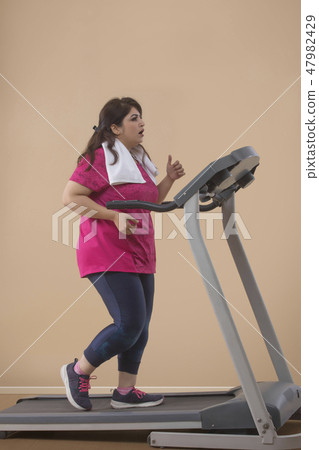 Fat Woman Doing Exercise On Treadmill in a gym 47982429
