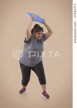Woman Frustrated From Her Weight Throwing Scale Woman Frustrated From Her Weight Throwing Scale 47982471
