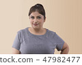 Smiling overweight woman looking at the camera 47982477