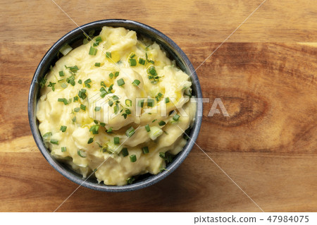 Pomme puree, an overhead photo of a bowl of mashed potatoes with herbs, shot from the top on a 47984075