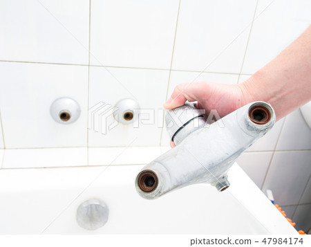 Plumber holding a dual outlet shower faucet Plumber holding a dual outlet shower faucet 47984174