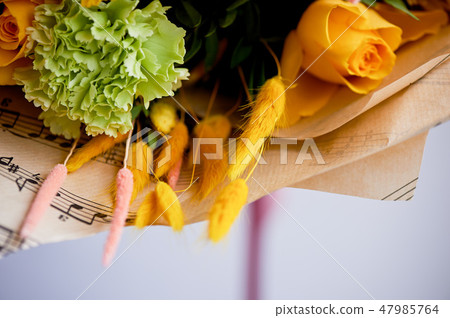 Yellow bouquet with green carnation, in the composition of chrysanthemums, roses and dyed grains 47985764
