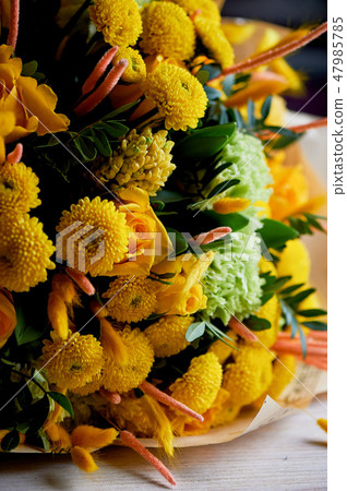 Yellow bouquet with green carnation, in the composition of chrysanthemums, roses and dyed grains 47985785