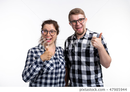 Nerds, geek, bespectacled and funny people concept - a couple of nerds in glasses show us thumbs up 47985944