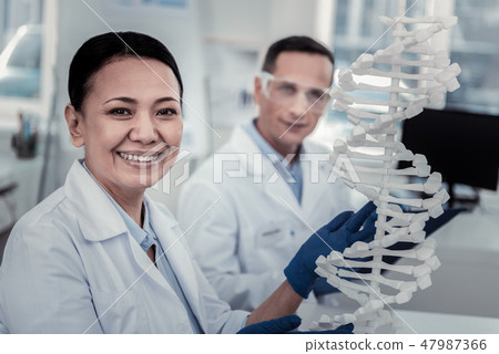 Smiling scientist trying to decode DNA secrets Smiling scientist trying to decode DNA secrets 47987366