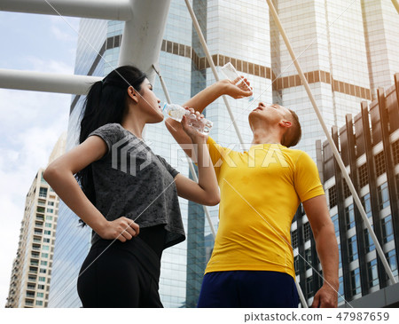 Athletes are drinking water on walking street. Athletes are drinking water on walking street. 47987659