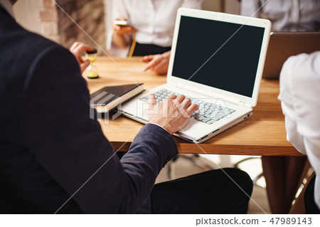 Close-up view of man's hands working on laptop 47989143