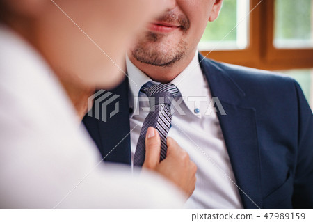 Closeup of man's tie being adjusted. Cropped Closeup of man's tie being adjusted. Cropped 47989159