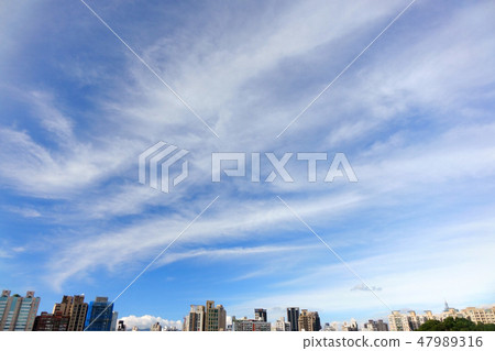 Modern city building and large fluffy clouds Modern city building and large fluffy clouds 47989316