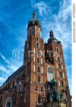 Church of St. Mary in the main Market Square on the background dramatic sky. Basilica Mariacka Church of St. Mary in the main Market Square on the background dramatic sky. Basilica Mariacka 47989893
