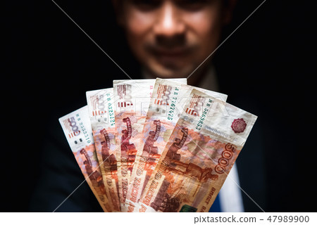 Russian money in front of the man face in the dark 47989900