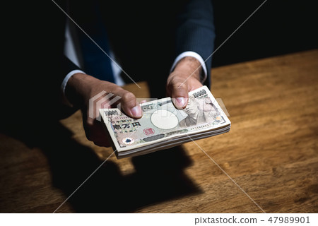 Businessman giving Japanese money in dark room Businessman giving Japanese money in dark room 47989901