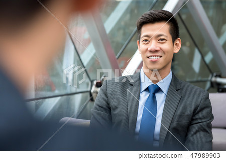 Smiling Asian businessman sitting at office lounge 47989903