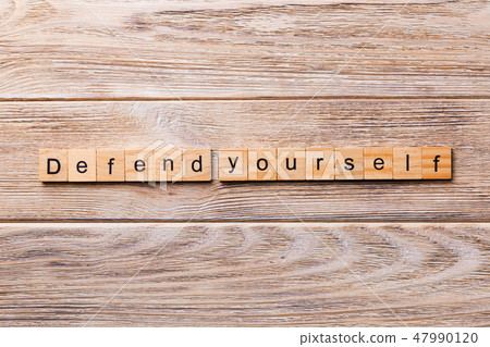 defend yourself word written on wood block. defend yourself word written on wood block. 47990120
