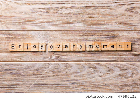 Enjoy Every Moment word written on wood block. Enjoy Every Moment word written on wood block. 47990122