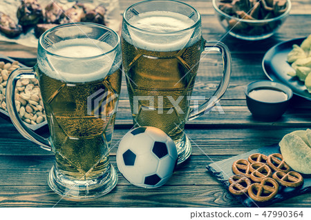 Appetizers and beer on the table for watch the football match. Appetizers and beer on the table for watch the football match. 47990364