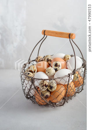 Different types of eggs in a basket. Different types of eggs in a basket. 47990553