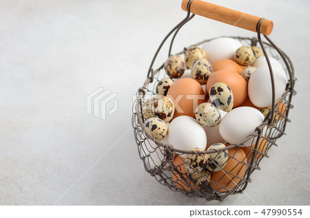 Different types of eggs in a basket. 47990554