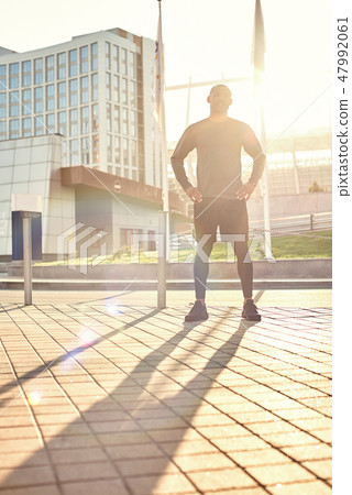Enjoying healthy lifestyle. Full length portrait of sporty african man in sportswear enjoying sunny Enjoying healthy lifestyle. Full length portrait of sporty african man in sportswear enjoying sunny 47992061