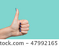 Woman making like gesture putting thumb up 47992165