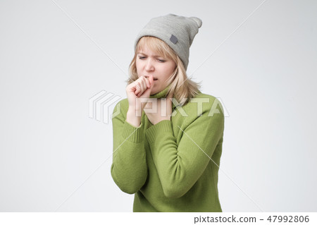Unhealthy young blonde woman coughing a lot, suffering with cough, has a chest pain 47992806
