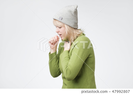 Unhealthy young blonde woman coughing a lot, suffering with cough, has a chest pain Unhealthy young blonde woman coughing a lot, suffering with cough, has a chest pain 47992807