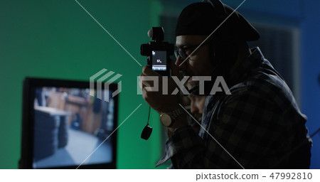 Young director giving instructions on a film set Young director giving instructions on a film set 47992810