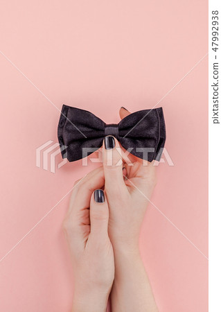 Black bow tie woman hand for men fathers concept Black bow tie woman hand for men fathers concept 47992938