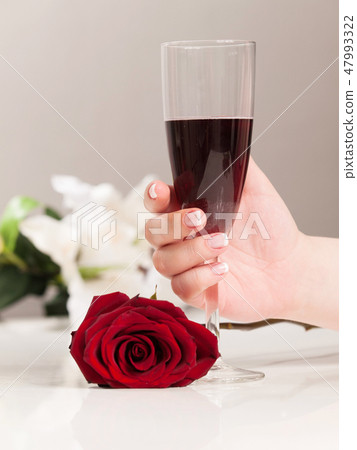 Woman hand with nail polish holding glass of wine 47993322