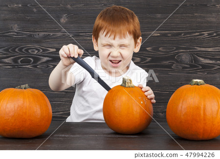 redhead boy with red pumpkins 47994226