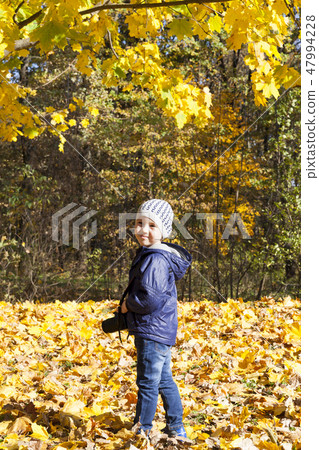 Child photographer in the autumn park Child photographer in the autumn park 47994228