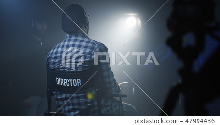 Director sitting in his chair on a film set 47994436