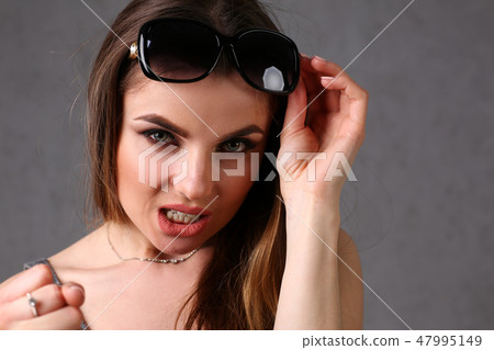 Beautiful young smiling brunette girl wearing sunglasses Beautiful young smiling brunette girl wearing sunglasses 47995149